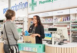 Staff member serving customer at a Boots store
