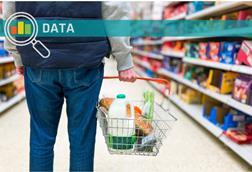 Man holding shopping basket with bread and milk groceries in supermarket